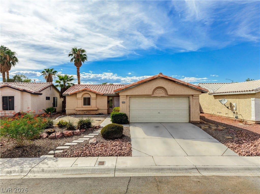 5239 Ferrell Mountain Court, North Las Vegas, NV 89031 Spanish tile roofing and desert-friendly landscaping frame this classic single-story stucco home.