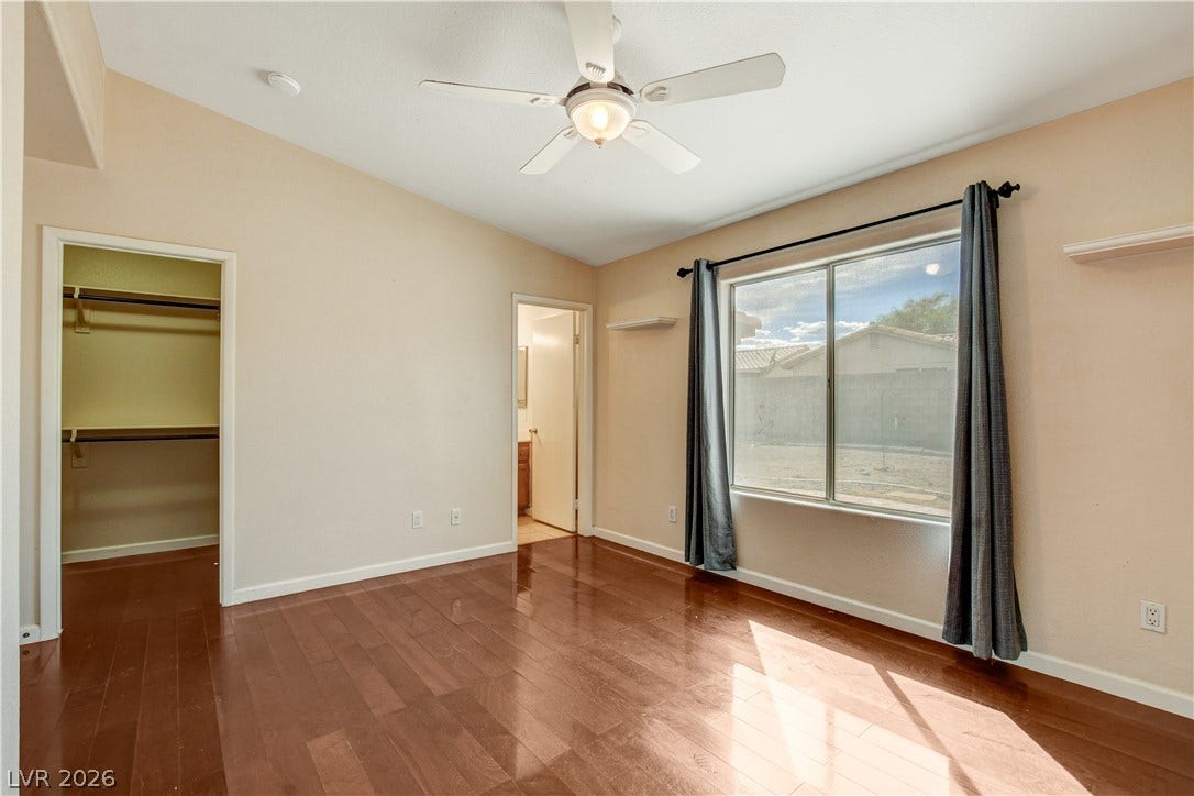 5239 Ferrell Mountain Court, North Las Vegas, NV 89031 Warm wood flooring and an open closet define this inviting bedroom space.