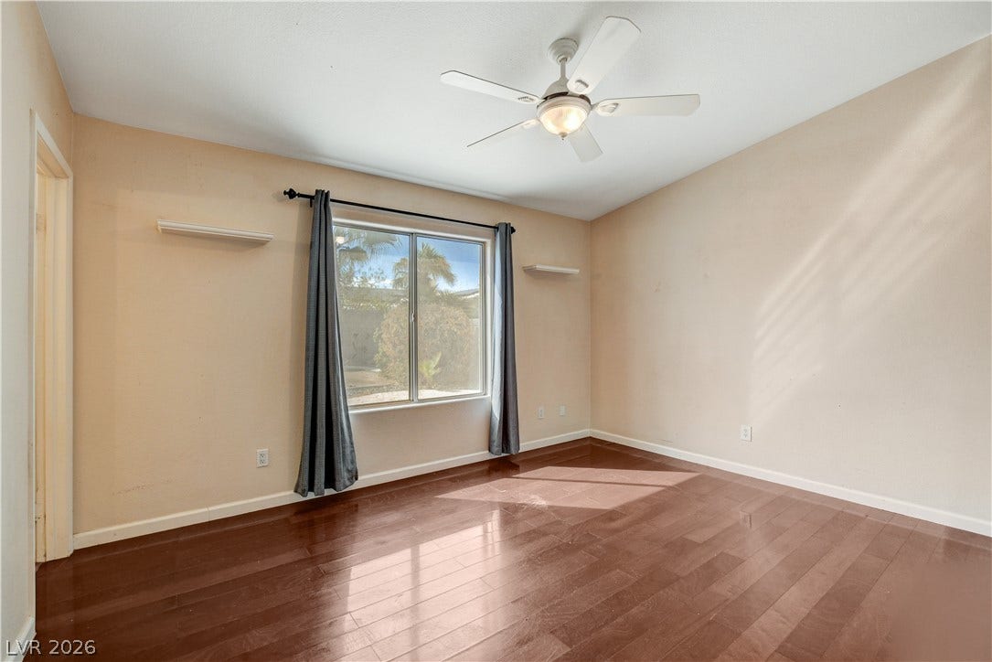 5239 Ferrell Mountain Court, North Las Vegas, NV 89031 Gleaming hardwood floors and a wide window create an inviting secondary bedroom.