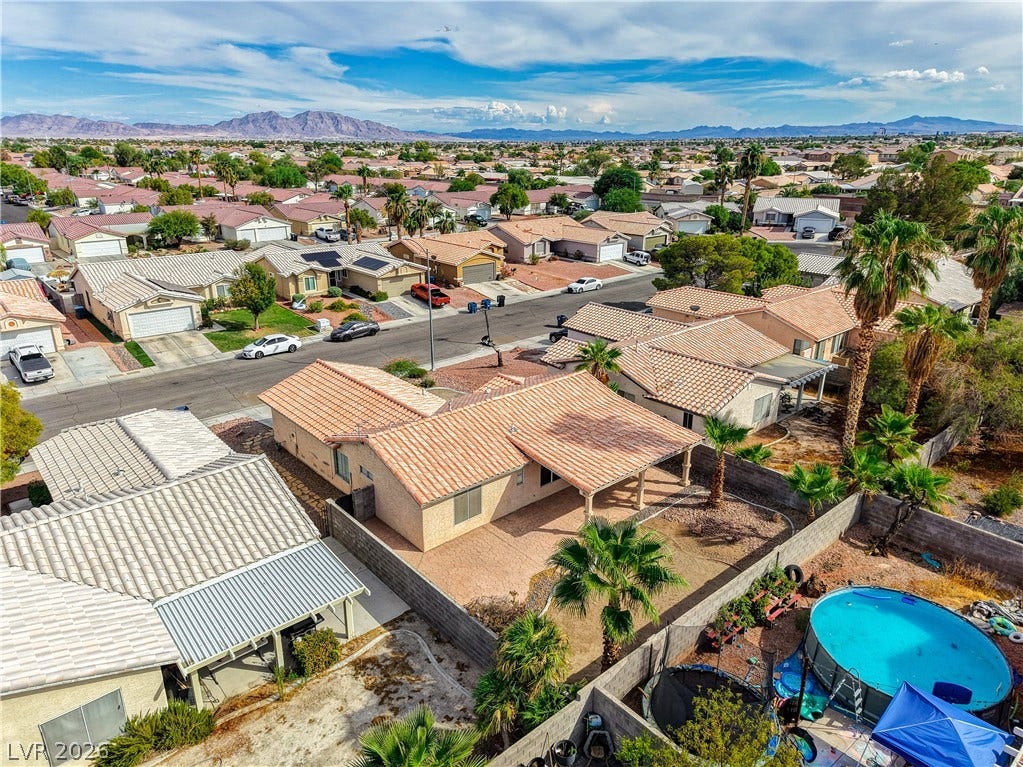 5239 Ferrell Mountain Court, North Las Vegas, NV 89031 Distant mountain ranges frame a charming neighborhood filled with tile-roofed homes.