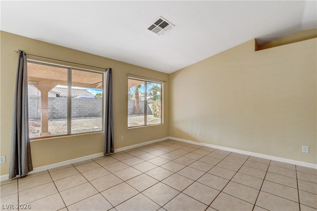 5239 Ferrell Mountain Court, North Las Vegas, NV 89031 Tiled flooring and large windows looking out to the yard define this versatile living space.