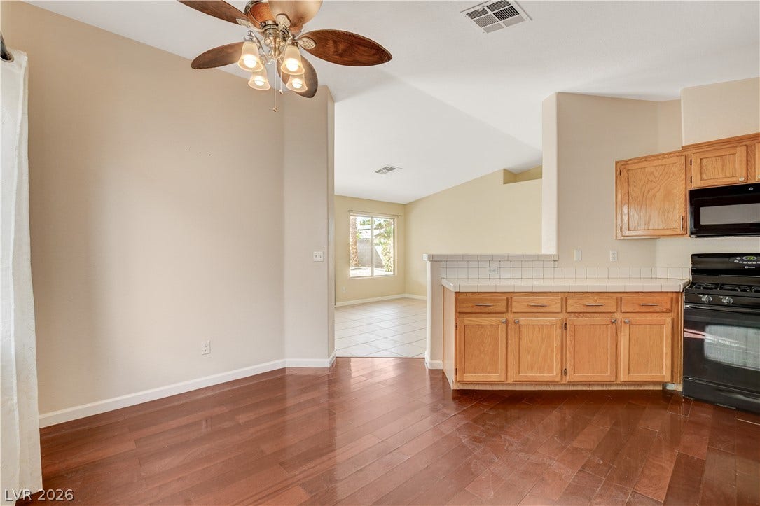 5239 Ferrell Mountain Court, North Las Vegas, NV 89031 Rich wood flooring connects the dining area seamlessly to the open kitchen space.
