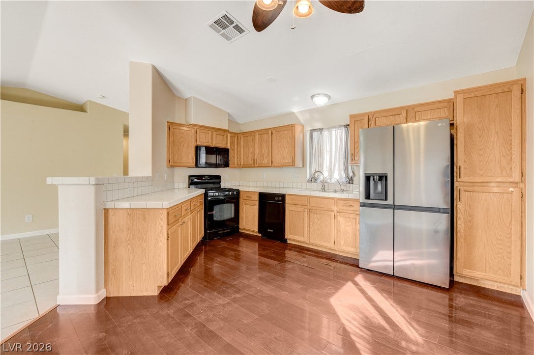 5239 Ferrell Mountain Court, North Las Vegas, NV 89031 Rich hardwood flooring anchors this kitchen complete with abundant cabinetry and clean countertops.