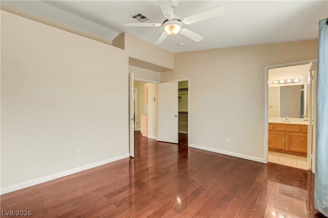 5239 Ferrell Mountain Court, North Las Vegas, NV 89031 Polished wood floors and high ceilings define this primary suite with an attached bath.
