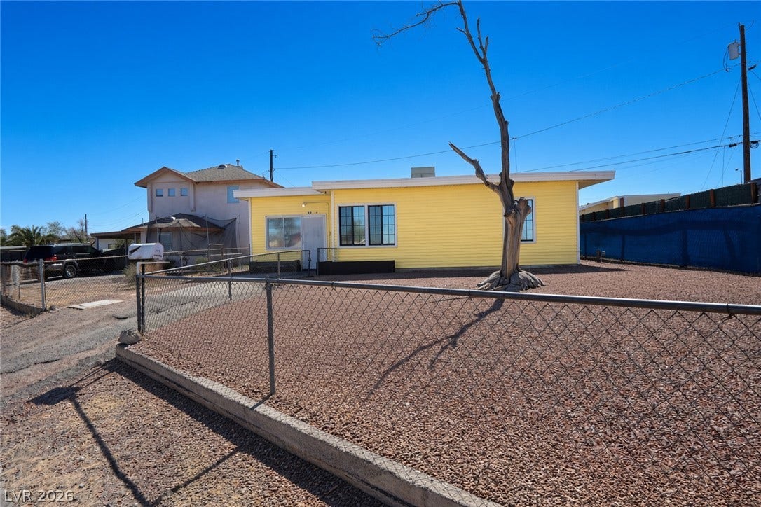123 W Victory Road, Henderson, NV 89015 Chain-link fencing secures the front yard of this single-level home set against a clear sky.