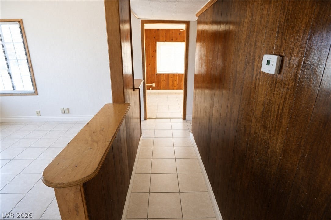 123 W Victory Road, Henderson, NV 89015 Tiled flooring and warm wood paneling create a classic transition between living spaces.