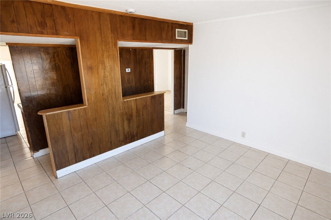123 W Victory Road, Henderson, NV 89015 Tiled flooring and wood-paneled accents define this versatile living space.