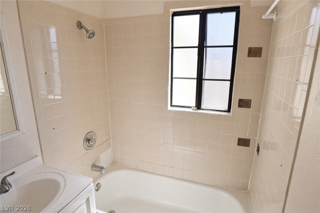 123 W Victory Road, Henderson, NV 89015 A classic tiled shower and tub combination surrounds a multi-pane frosted window.