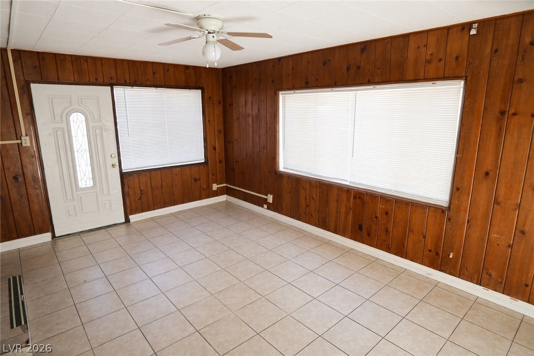 123 W Victory Road, Henderson, NV 89015 Rich wood paneling lines the walls of this entry room featuring durable tile flooring.