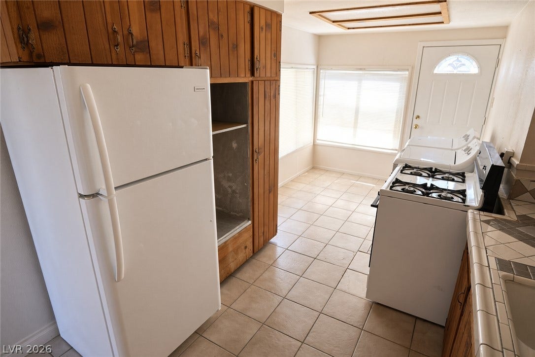 123 W Victory Road, Henderson, NV 89015 Tiled flooring and natural wood cabinetry define this functional culinary space.