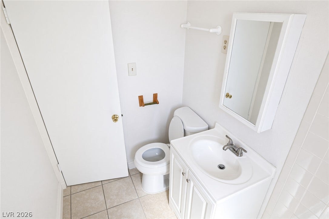 123 W Victory Road, Henderson, NV 89015 A classic tiled floor elevates this tidy bathroom with a medicine cabinet and functional vanity.