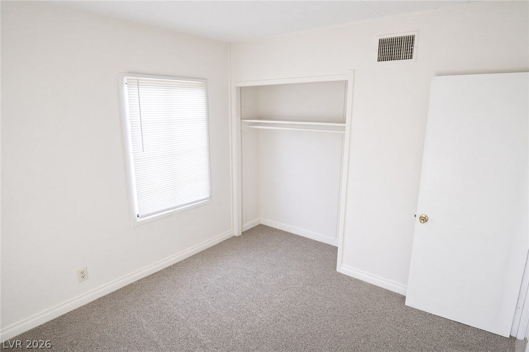 123 W Victory Road, Henderson, NV 89015 A windowed bedroom features soft wall-to-wall carpeting and built-in closet storage.