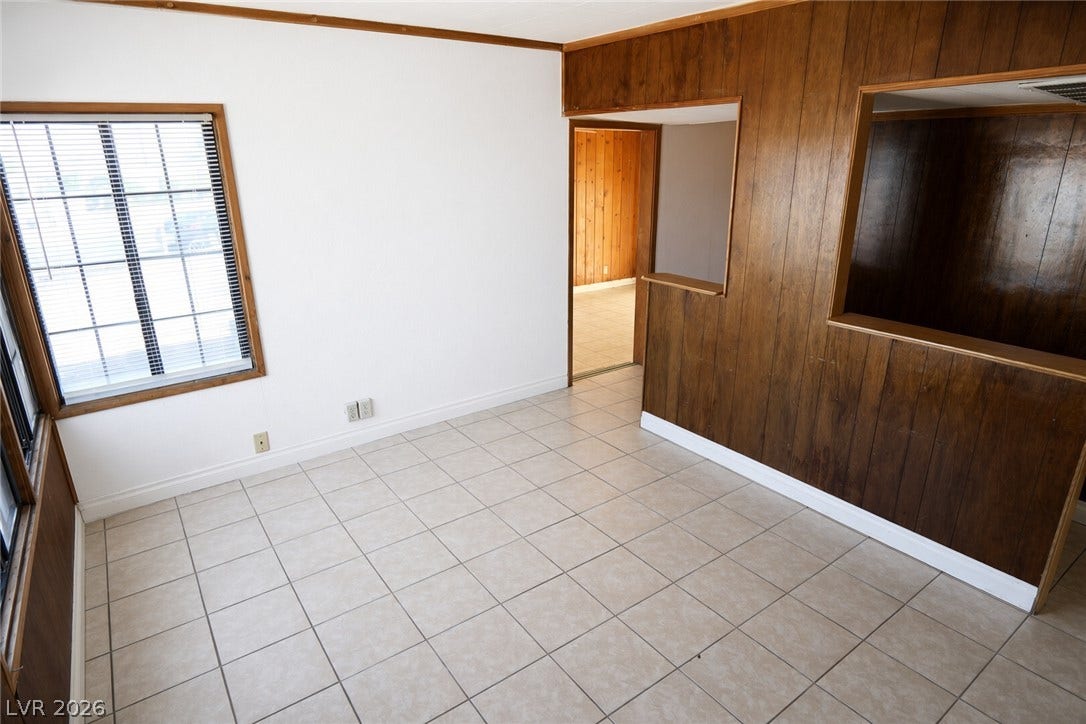 123 W Victory Road, Henderson, NV 89015 Tiled flooring and warm wood paneling details define this versatile living area.