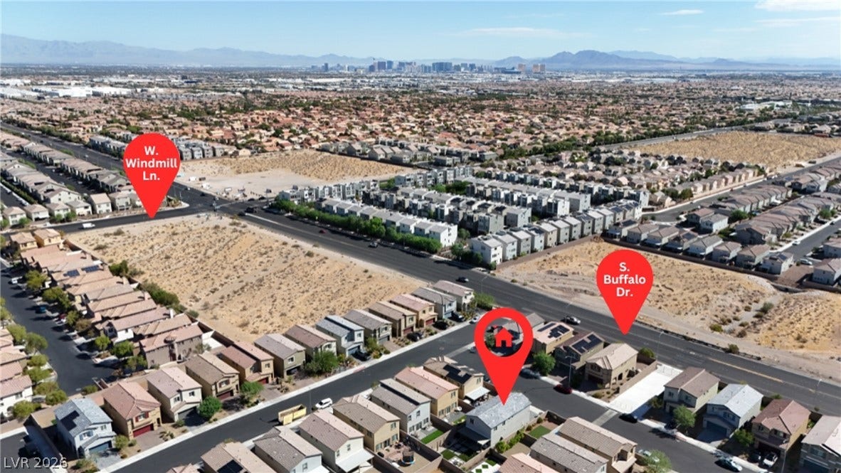 An aerial perspective reveals the residential community set against distant mountain peaks.