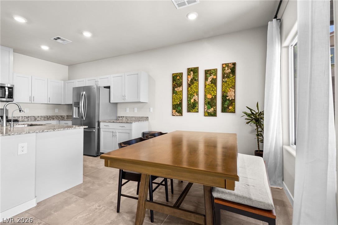 Gleaming tile floors and recessed lighting enhance this bright dining area adjacent to the kitchen.