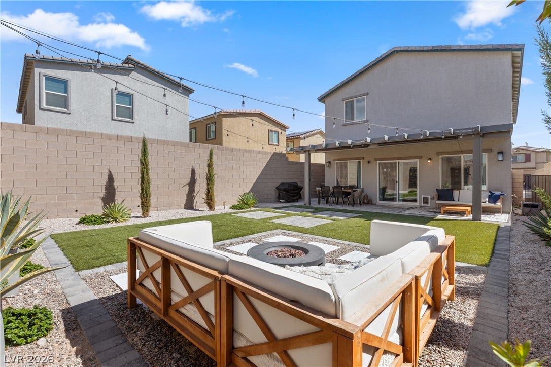 A block wall encloses this neat backyard featuring turf and a covered patio area.