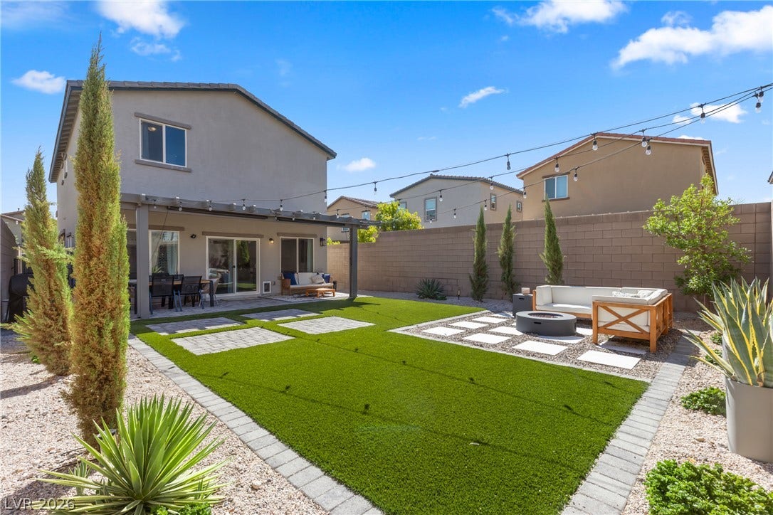 An inviting backyard oasis showcases structured paver designs set against clean geometric turf installations.