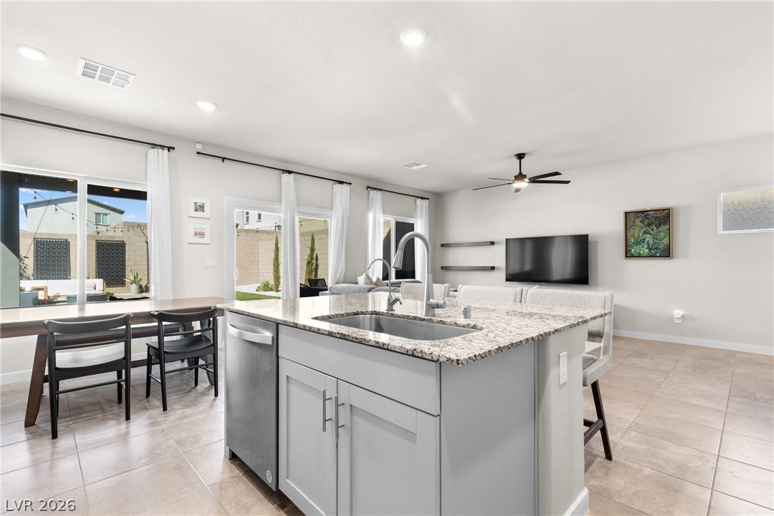 An open floor plan connects the kitchen island to the bright dining and living areas.
