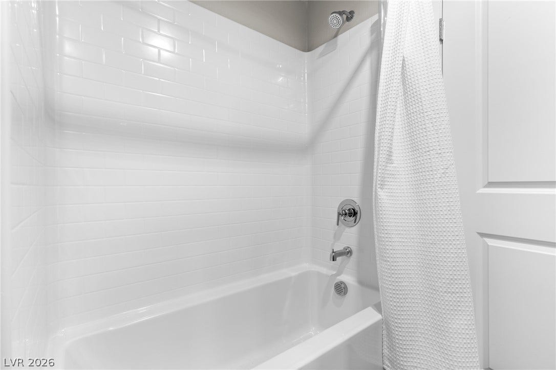 Crisp subway tile surrounds this classic soaking tub and shower combination.