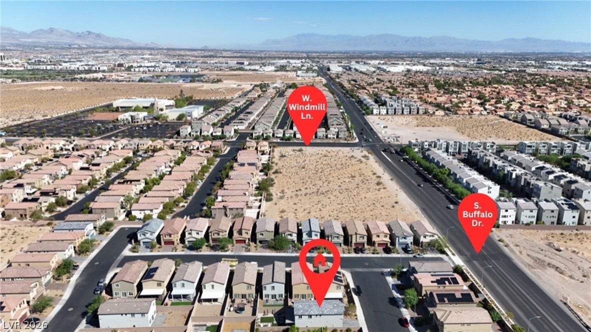 An aerial perspective captures the residential neighborhood surrounded by sweeping mountain views.