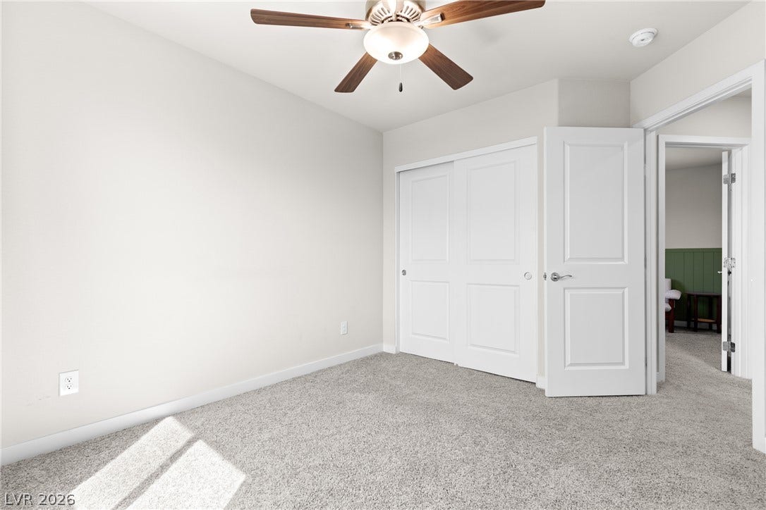 Soft carpeting pairs with neutral walls in this comfortable secondary bedroom.