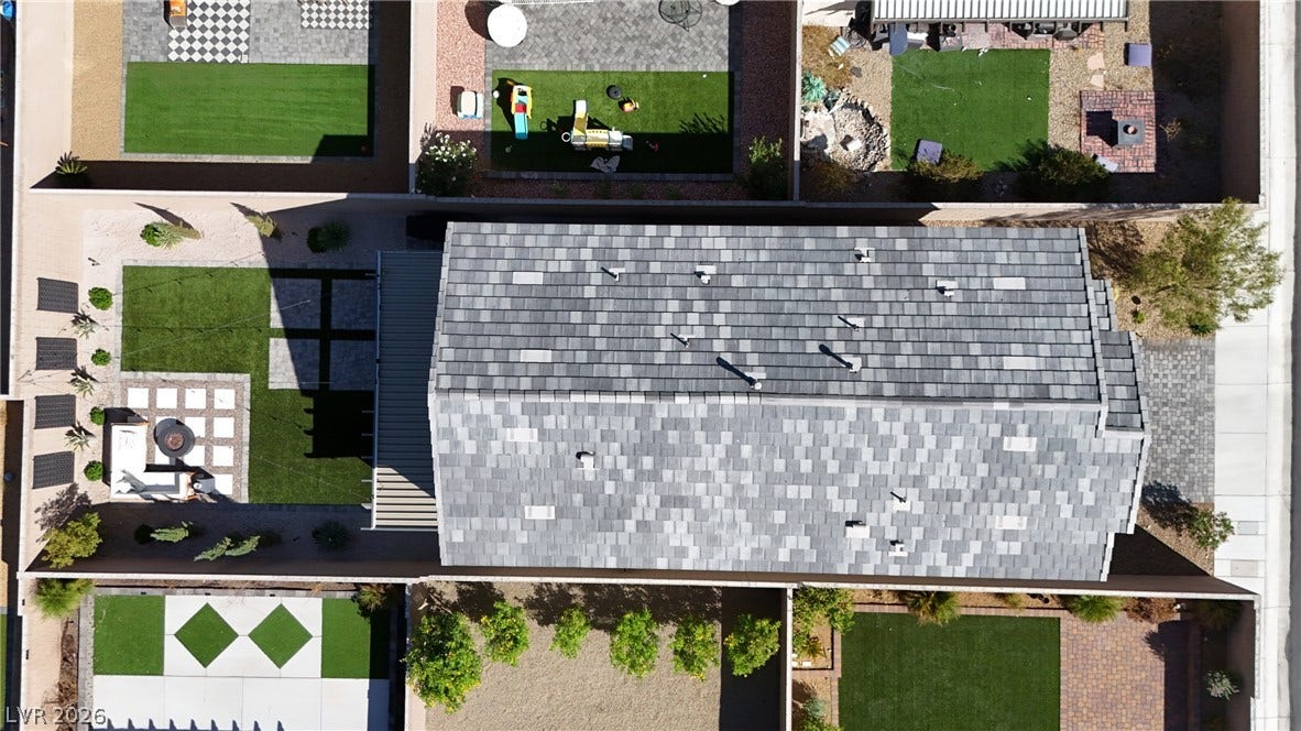 An aerial view highlights the clean lines of the tiled roof and manicured backyard design.