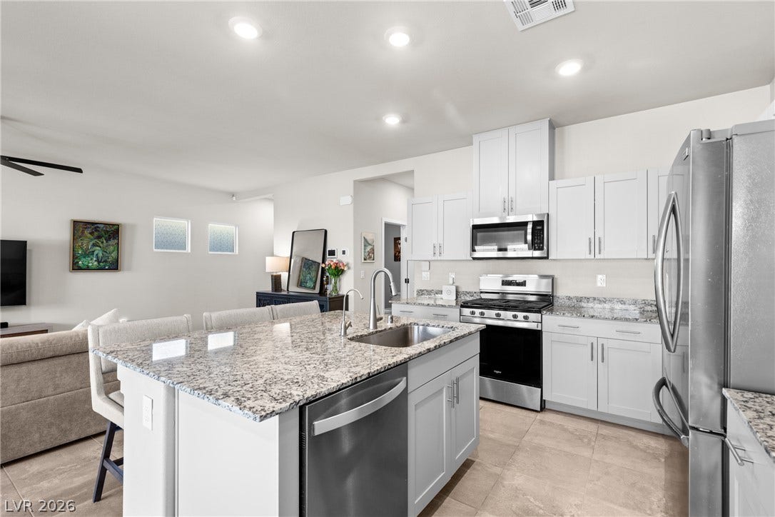 Polished granite countertops and classic cabinetry anchor this modern kitchen.