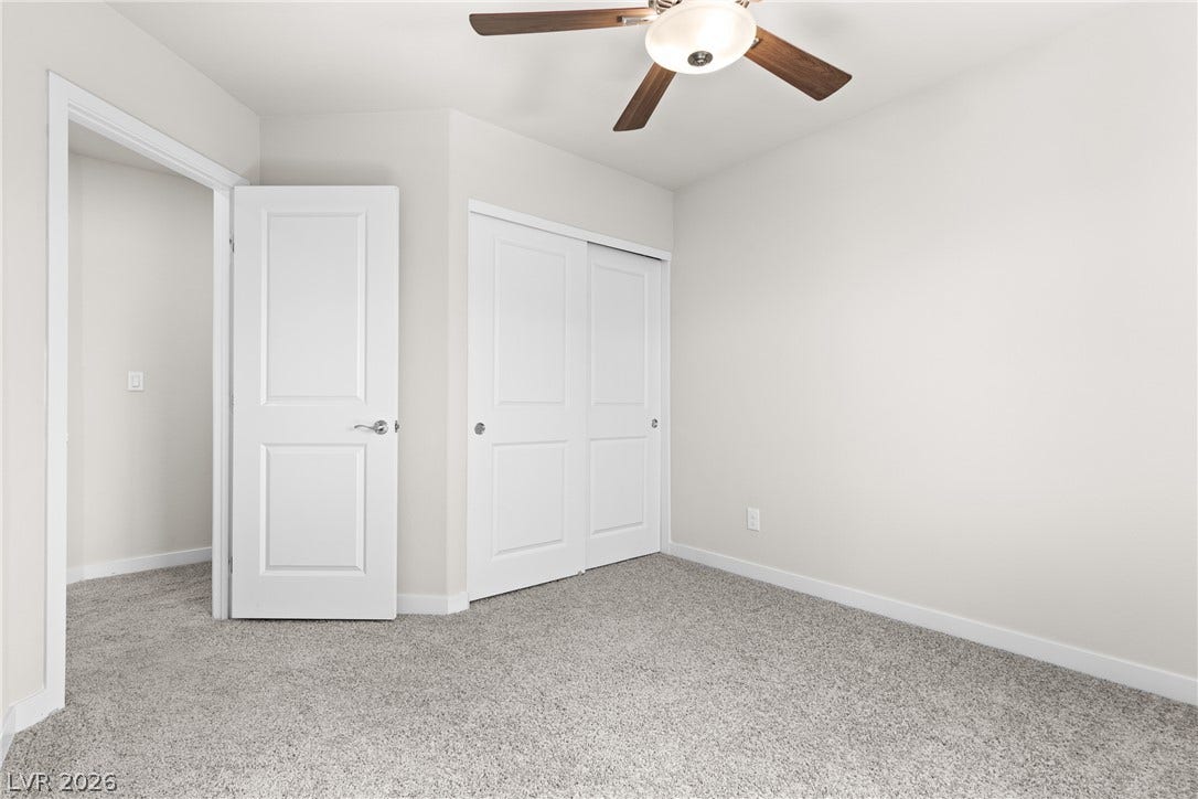 Soft carpeting pairs with neutral walls in this comfortable secondary bedroom.