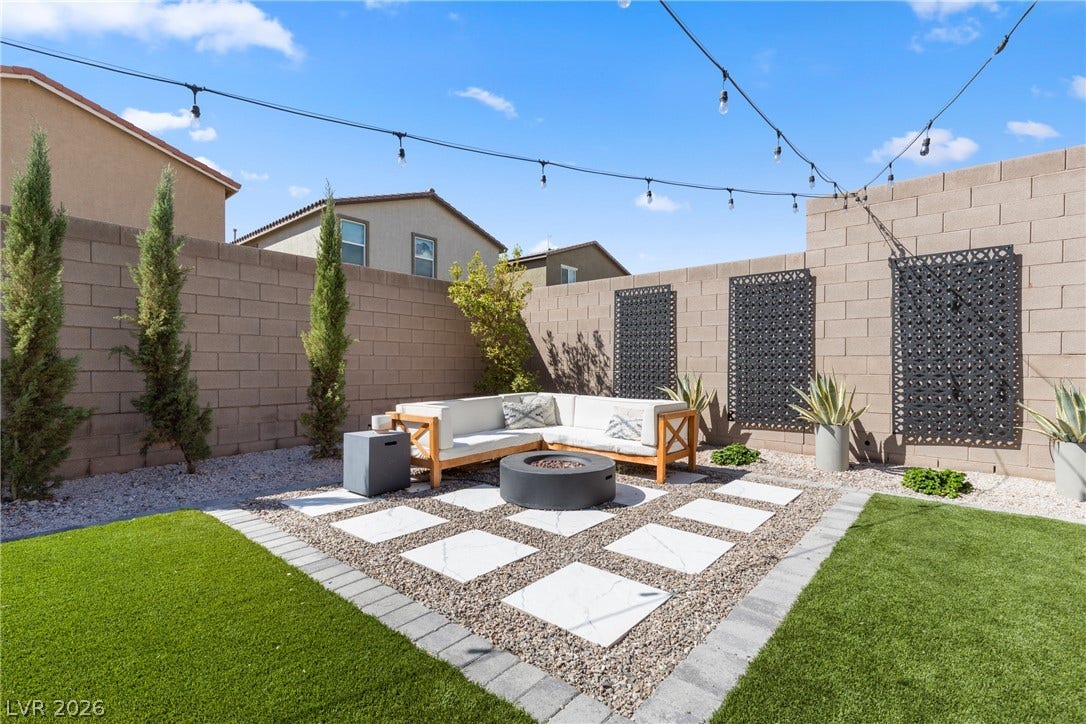 Neat pavers and low-maintenance landscaping create an inviting backyard retreat.