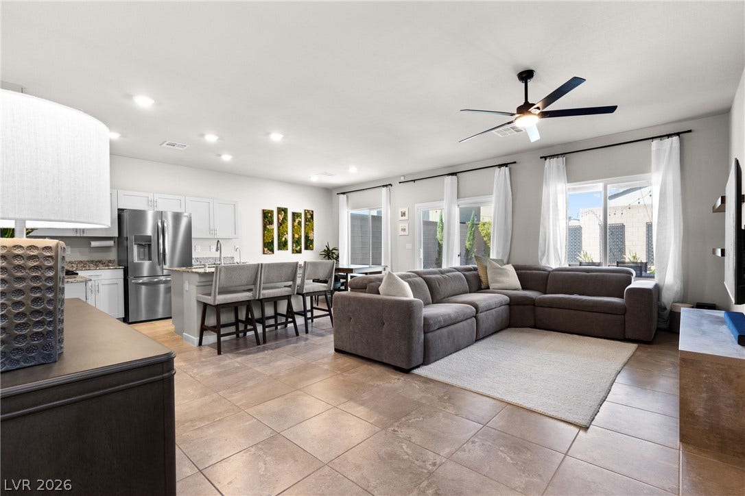 An open-concept living area and kitchen features tiled flooring and glass sliding doors.