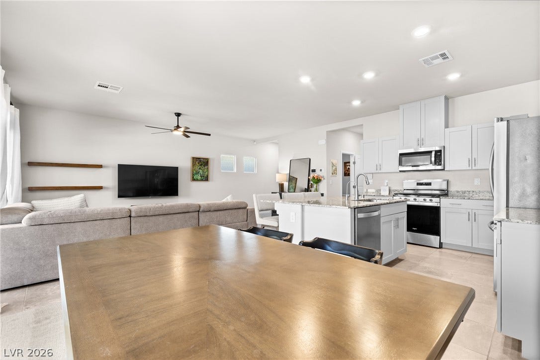 An open floorplan seamlessly connects the dining space, modern kitchen, and comfortable living areas.