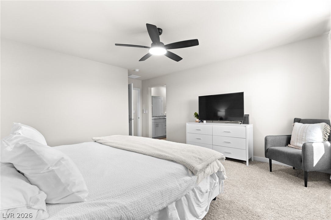 Soft wall tones and plush carpeting create a relaxing atmosphere in this primary bedroom retreat.