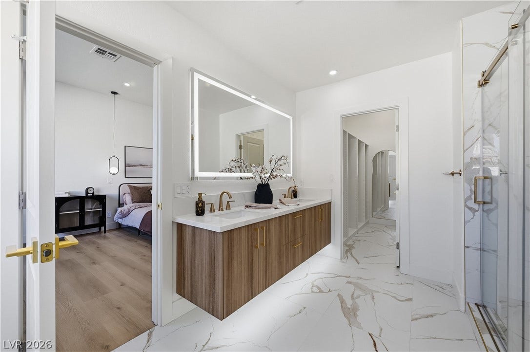 1612 Hidden Spring Drive, Las Vegas, NV 89117 Gleaming marble-patterned tile floors and a floating double vanity define this elegant primary bathroom.