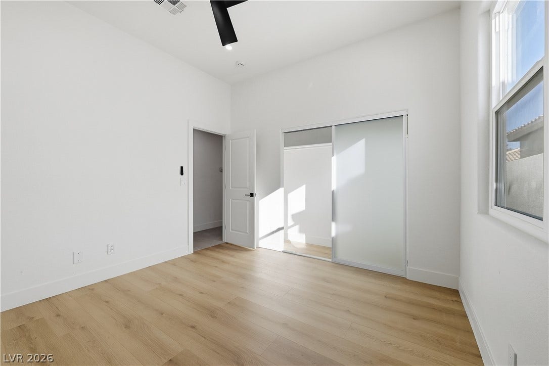 1612 Hidden Spring Drive, Las Vegas, NV 89117 Smooth wood floors and crisp white walls create a minimalist aesthetic in this modern bedroom.