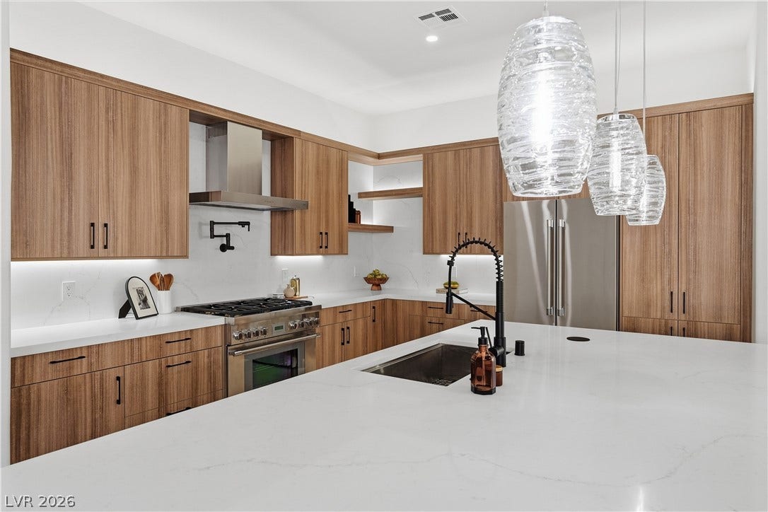 1612 Hidden Spring Drive, Las Vegas, NV 89117 Gleaming stone countertops and warm wood cabinetry define this chef-inspired workspace.