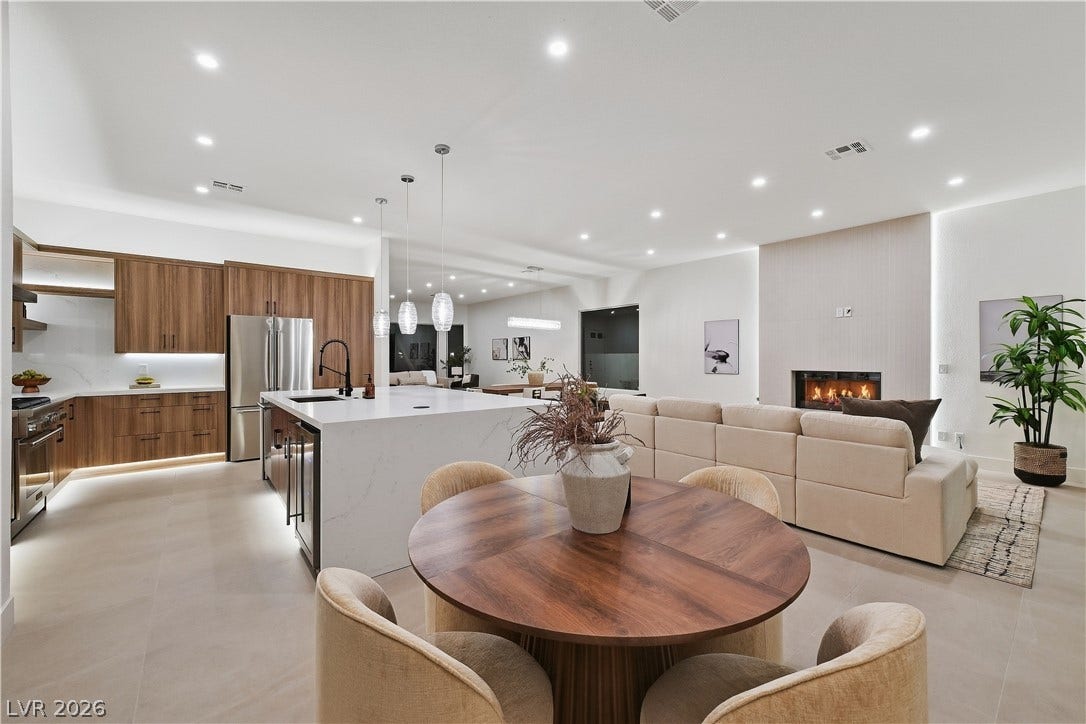 1612 Hidden Spring Drive, Las Vegas, NV 89117 An open floorplan seamlessly connects the modern kitchen, dining area, and fireplace-warmed living room.