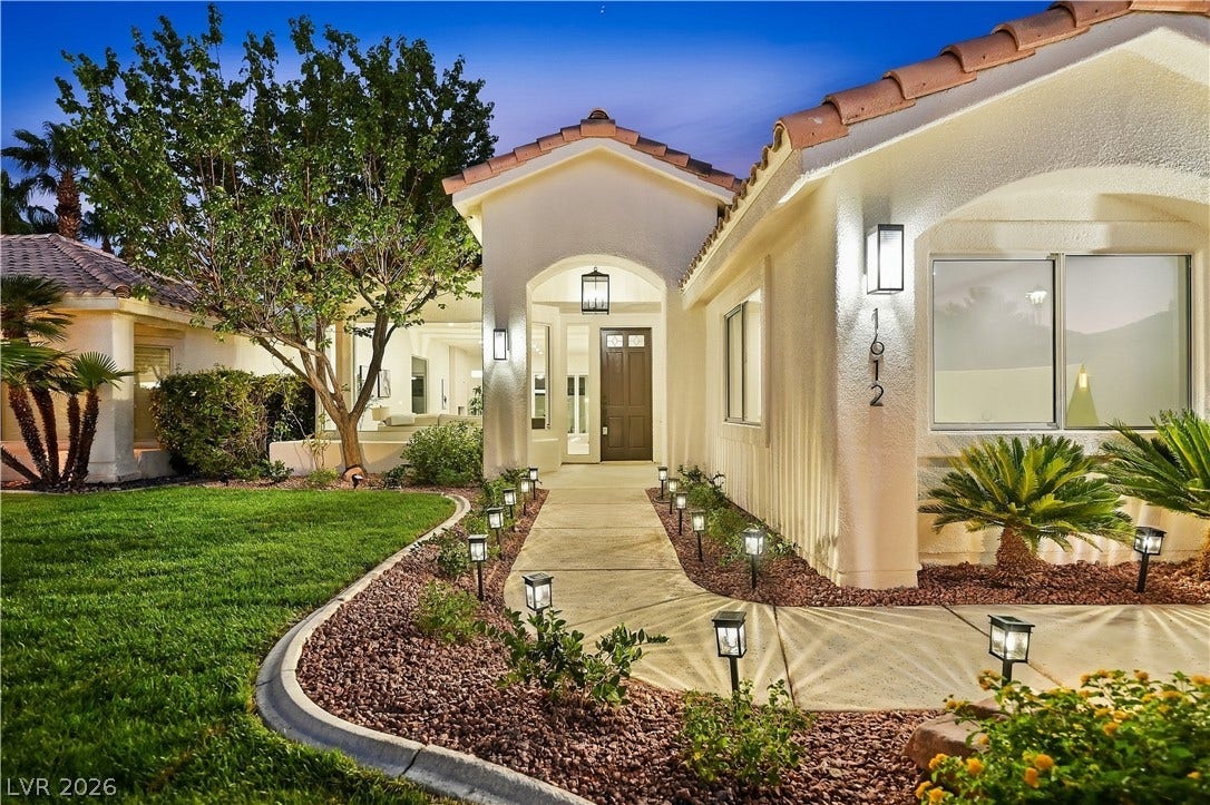 1612 Hidden Spring Drive, Las Vegas, NV 89117 An inviting concrete walkway guides visitors to the arched entry of this beautiful desert-style home.