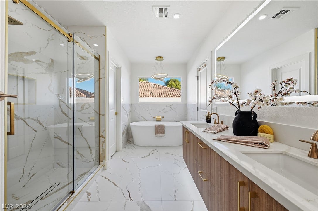 1612 Hidden Spring Drive, Las Vegas, NV 89117 Elegant stone finishes and a sleek soaking tub define this modern primary bath.