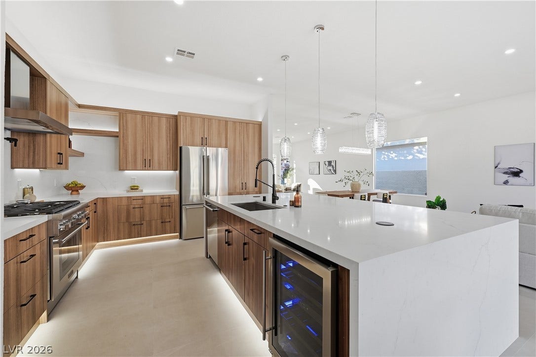 1612 Hidden Spring Drive, Las Vegas, NV 89117 Streamlined wooden cabinetry and a waterfall island anchor this open-concept kitchen.