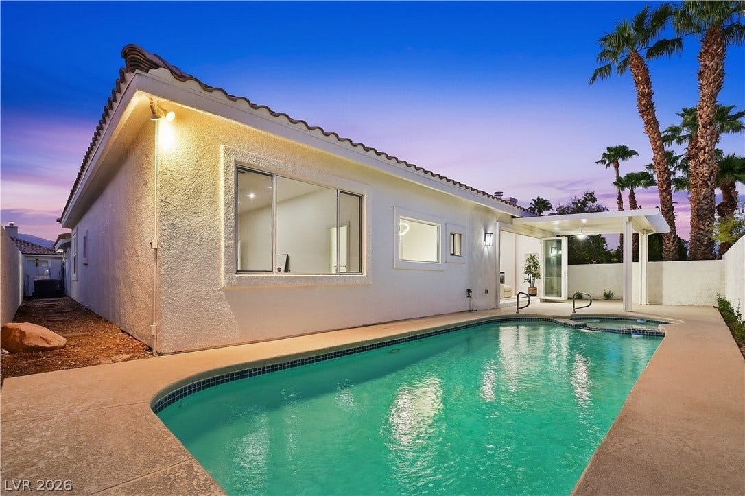 1612 Hidden Spring Drive, Las Vegas, NV 89117 An inviting backyard swimming pool and integrated spa sit adjacent to the stucco exterior.