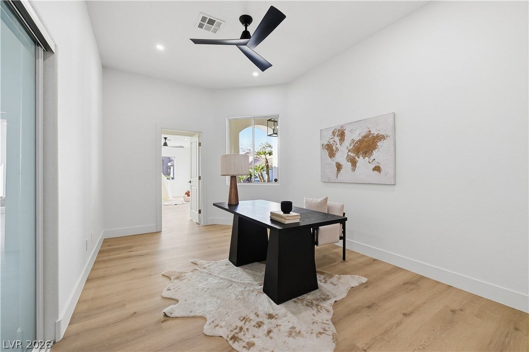 1612 Hidden Spring Drive, Las Vegas, NV 89117 Gleaming hardwood floors and a bright window highlight this versatile home office workspace.