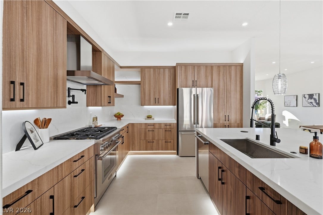 1612 Hidden Spring Drive, Las Vegas, NV 89117 Warm wood cabinetry pairs with pristine solid-surface countertops in this contemporary kitchen space.