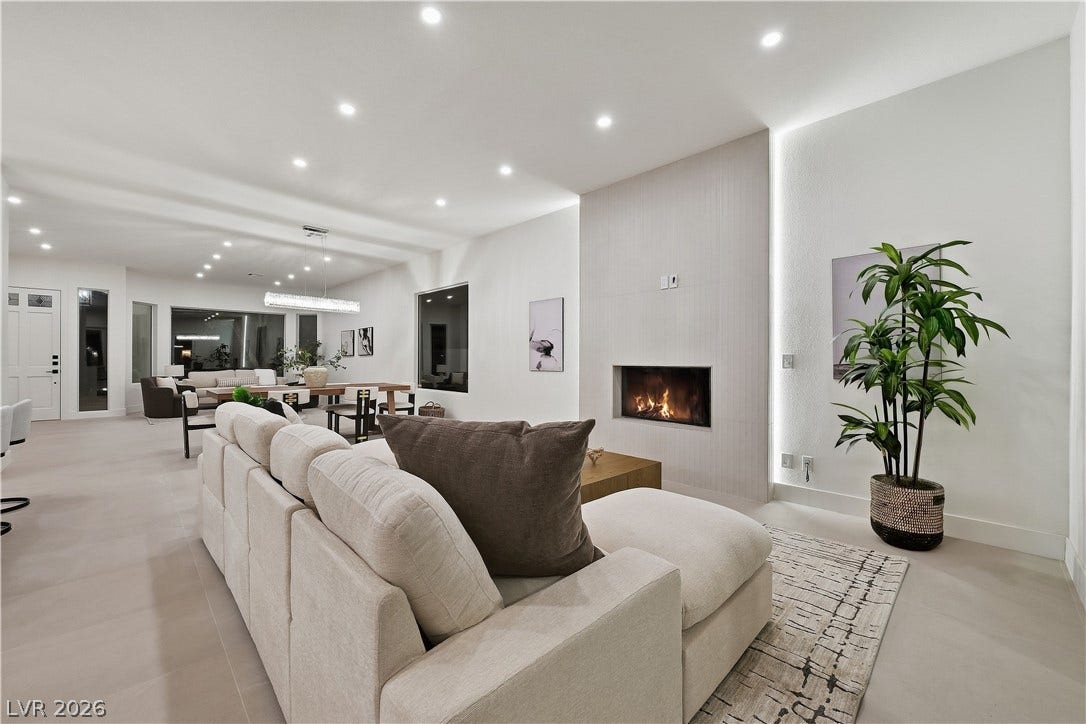 1612 Hidden Spring Drive, Las Vegas, NV 89117 Recessed lighting and a modern fireplace elevate this seamless open living area.
