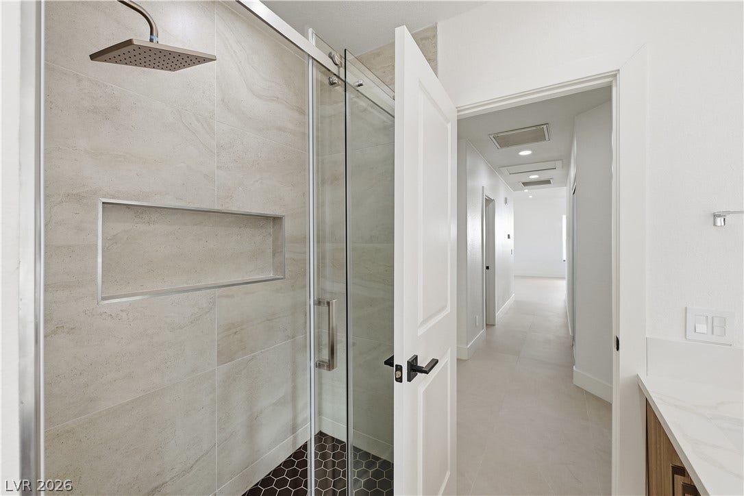 1612 Hidden Spring Drive, Las Vegas, NV 89117 Clean lines and modern tile finishes define this serene walk-in shower space.