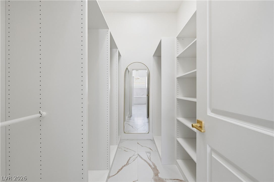 1612 Hidden Spring Drive, Las Vegas, NV 89117 Gleaming marble-patterned tile floors ground this custom walk-in closet with ample built-in shelving.