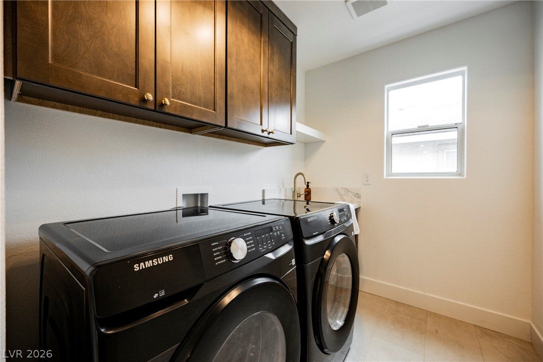 Rich wood cabinetry provides overhead storage in this functional utility area.