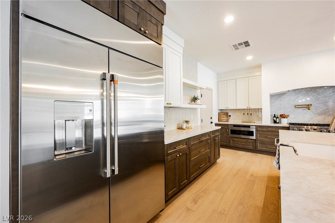 Warm hardwood flooring complements custom cabinetry and professional-grade appliances in this chef-inspired kitchen.