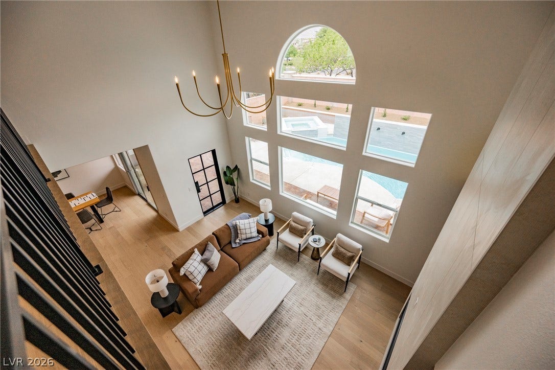 Double-height ceilings and a dramatic wall of windows highlight this light-filled living area.