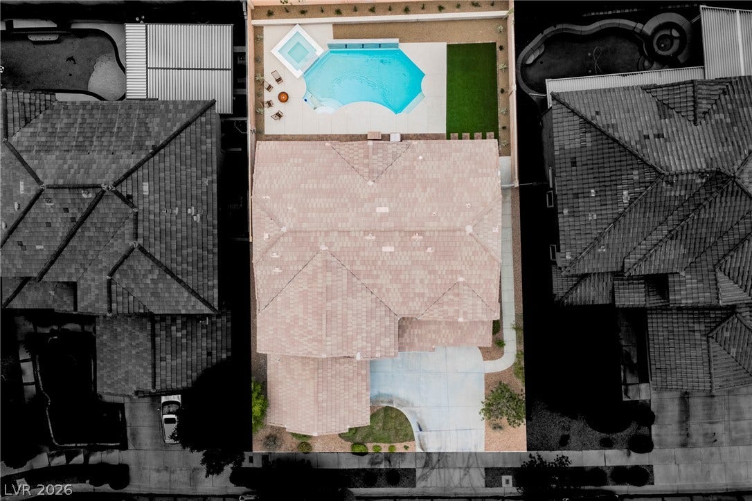 An aerial perspective showcases the tiled rooflines, backyard pool, and manicured landscaping.