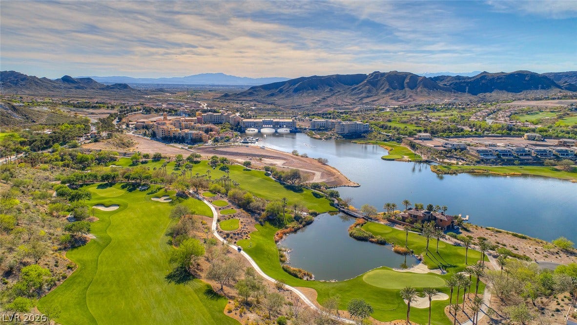 30 Sand Star Lane, Henderson, NV 89011 Rolling golf greens sit beside a calm lake with mountain ridges in the distance.